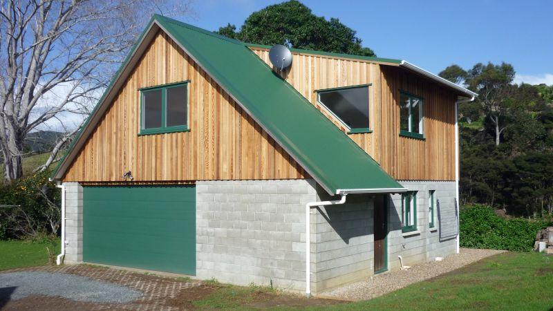 Beach bach extension is complete with new cedar cladding and large garage. A new bathroom, toilet, laundry, internal stairs, large living area and bedroom have been added.